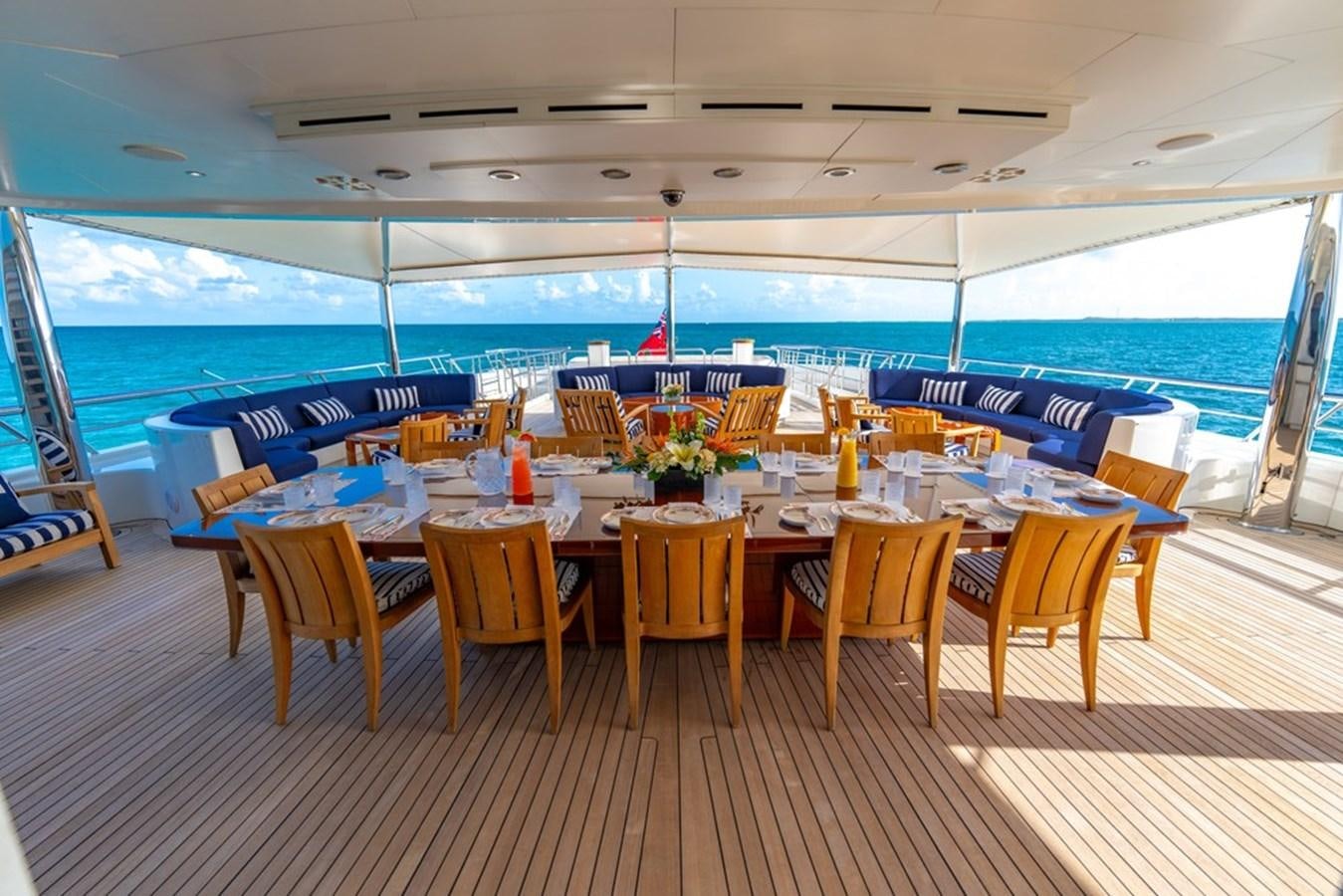 a table with chairs and a large window with a view of the water aboard AMADEUS Yacht for Sale