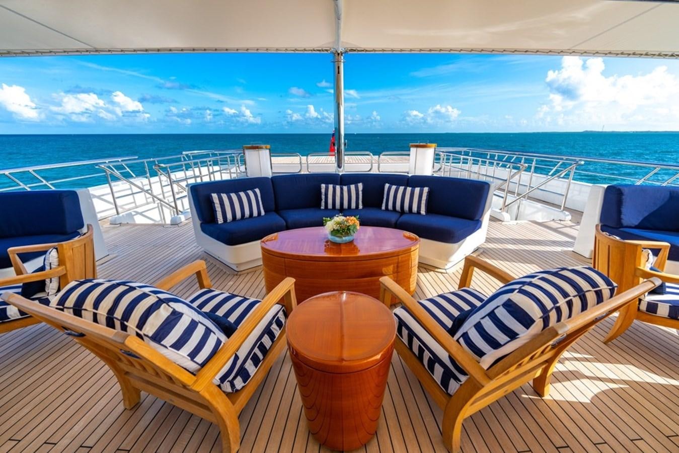 a deck with chairs and a table aboard AMADEUS Yacht for Sale