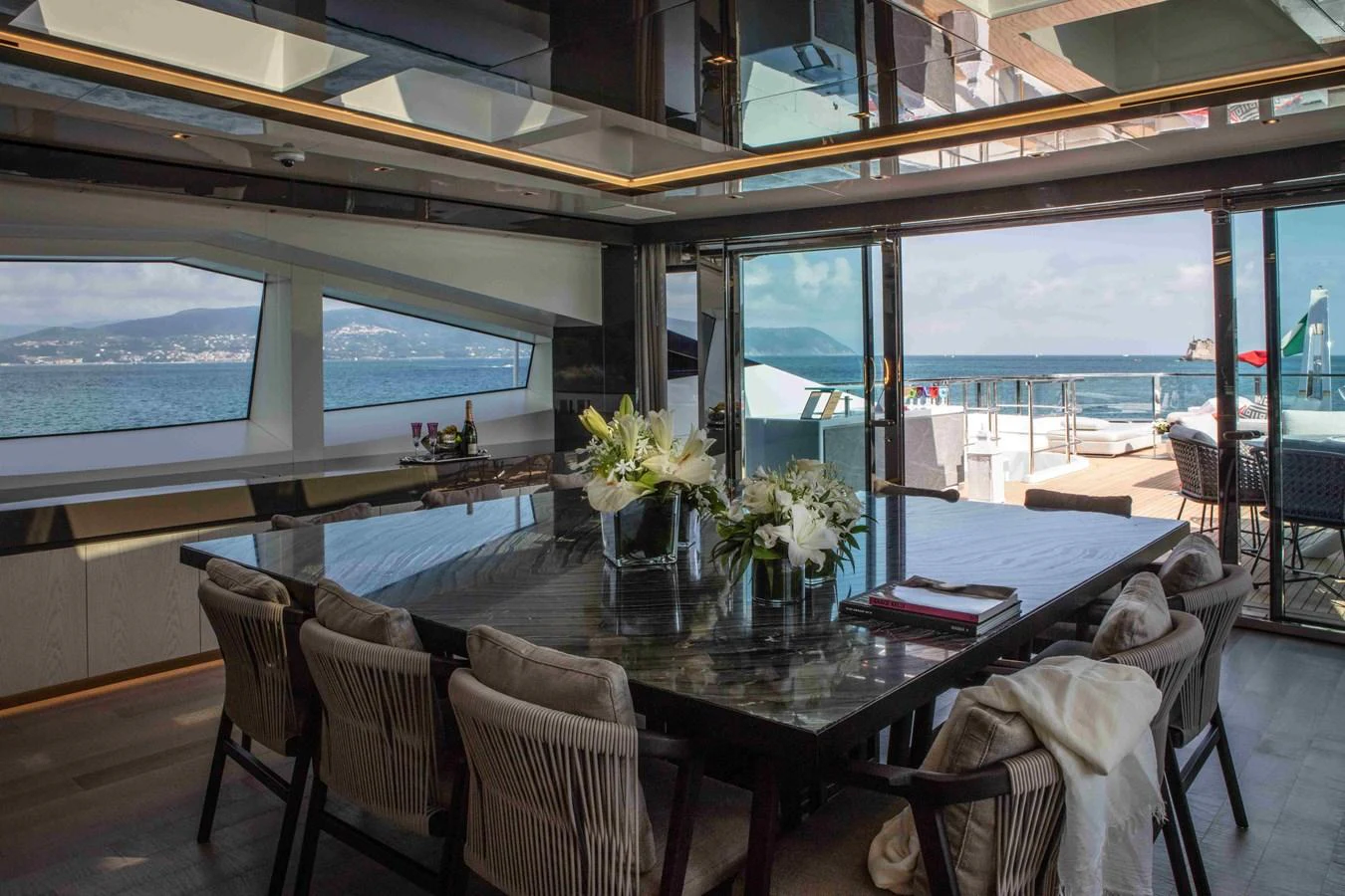 a dining room with a large window aboard MA Yacht for Sale