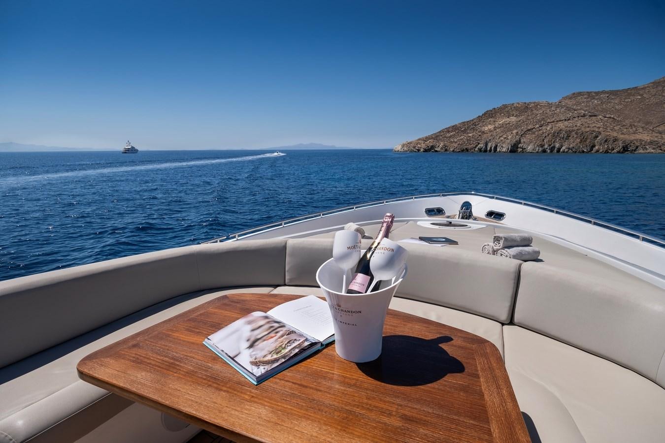 a table with a cup of coffee on it by the water aboard ICE Yacht for Sale