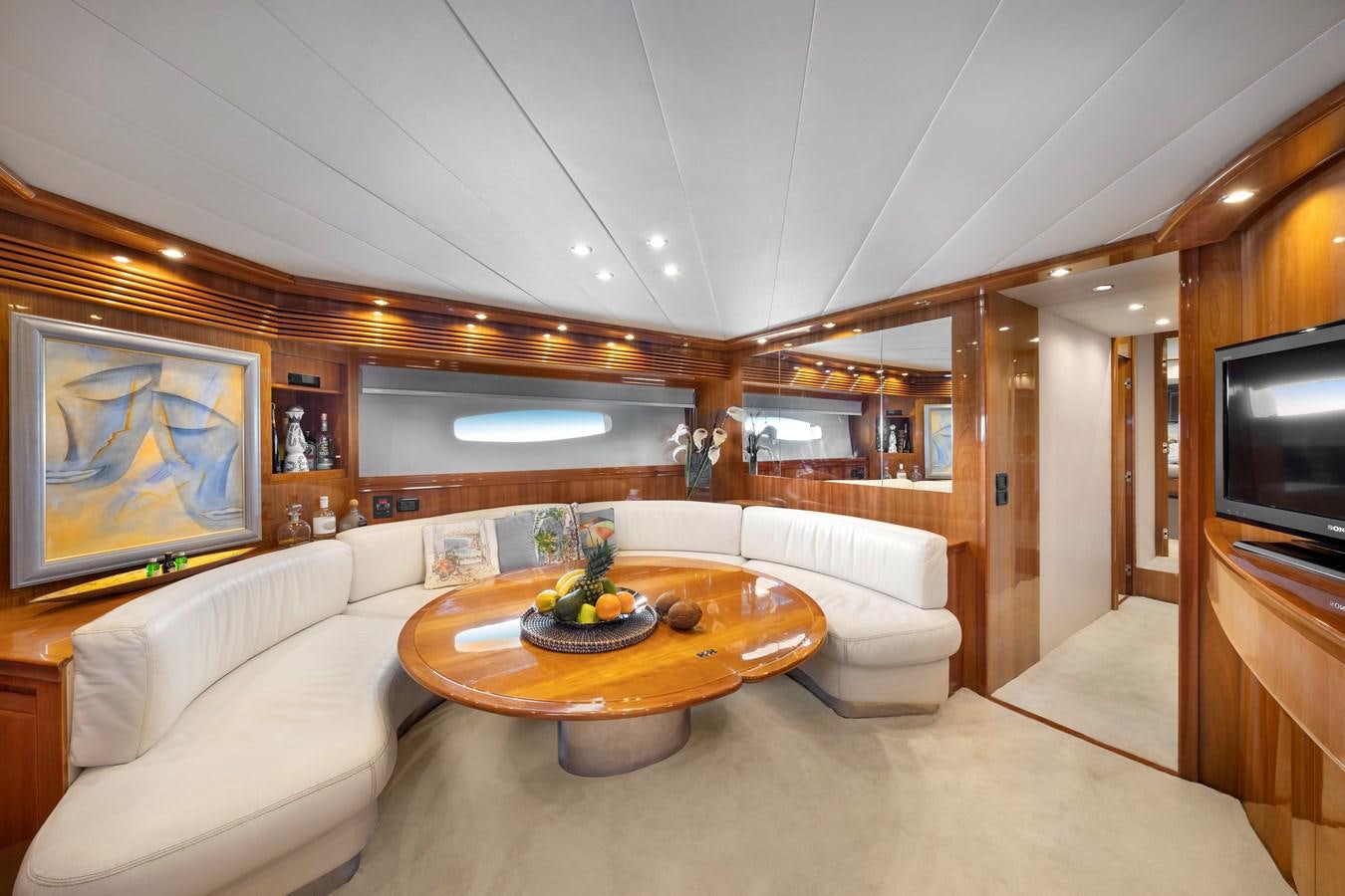 a living room with a table and couches aboard ICE Yacht for Sale
