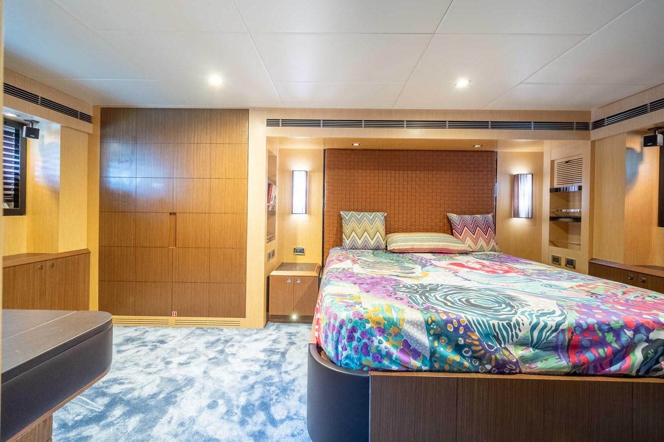 a bedroom with a bed and a desk aboard CHARISMA Yacht for Sale
