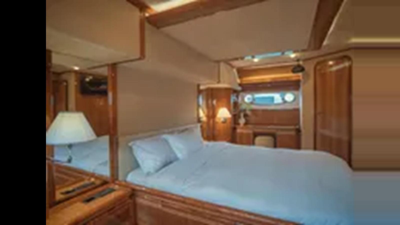 a bedroom with a bed and a dresser aboard 2004 FERRETTI YACHTS 810 Yacht for Sale
