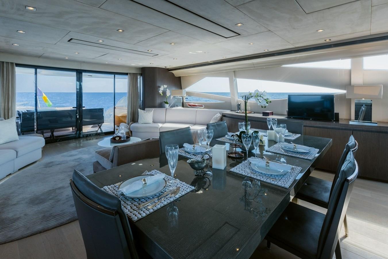 a large dining table in a living room aboard KOLAHA TWO Yacht for Sale