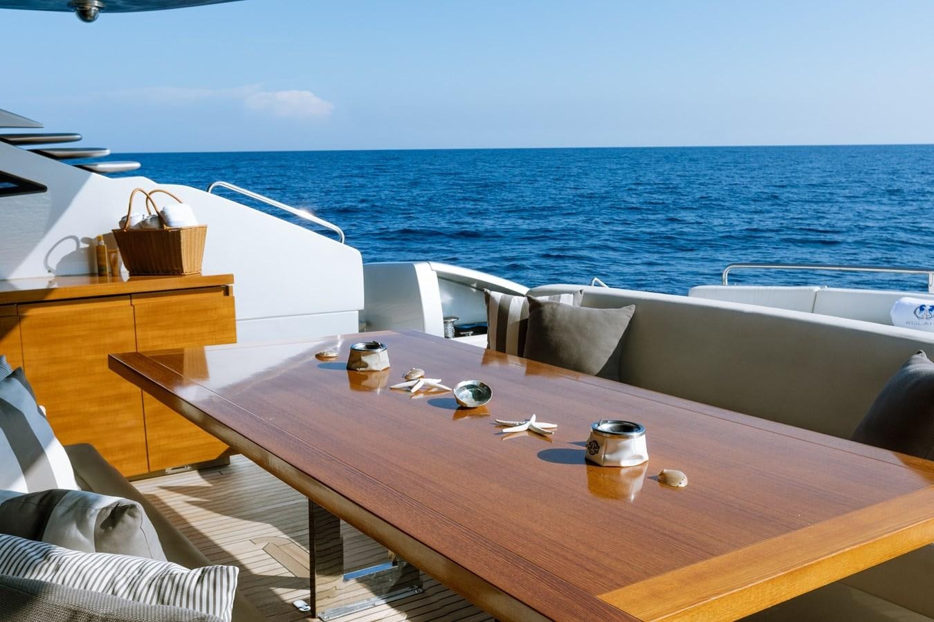 a table with chairs on it next to a large body of water aboard KOLAHA TWO Yacht for Sale