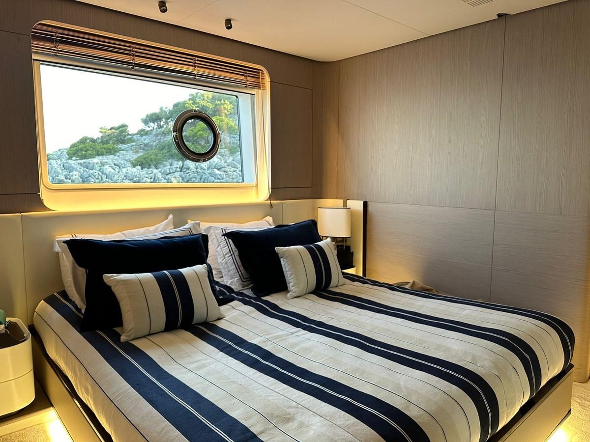 a bed with blue and white sheets aboard BETTY Yacht for Sale