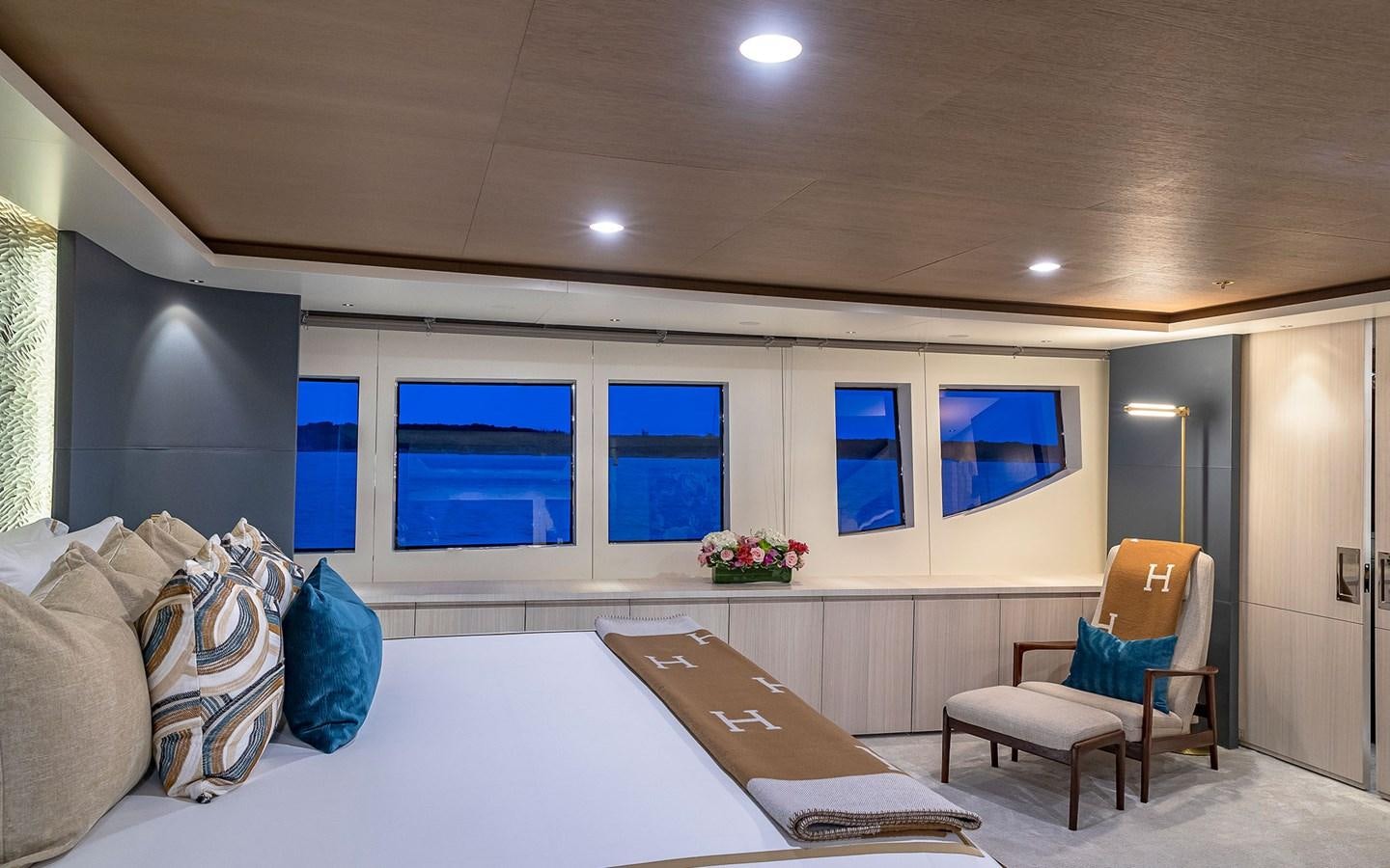 a room with a bed and a chair aboard REVERIE Yacht for Sale