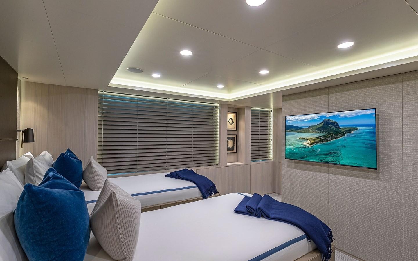 a room with a bed and a tv on the wall aboard REVERIE Yacht for Sale