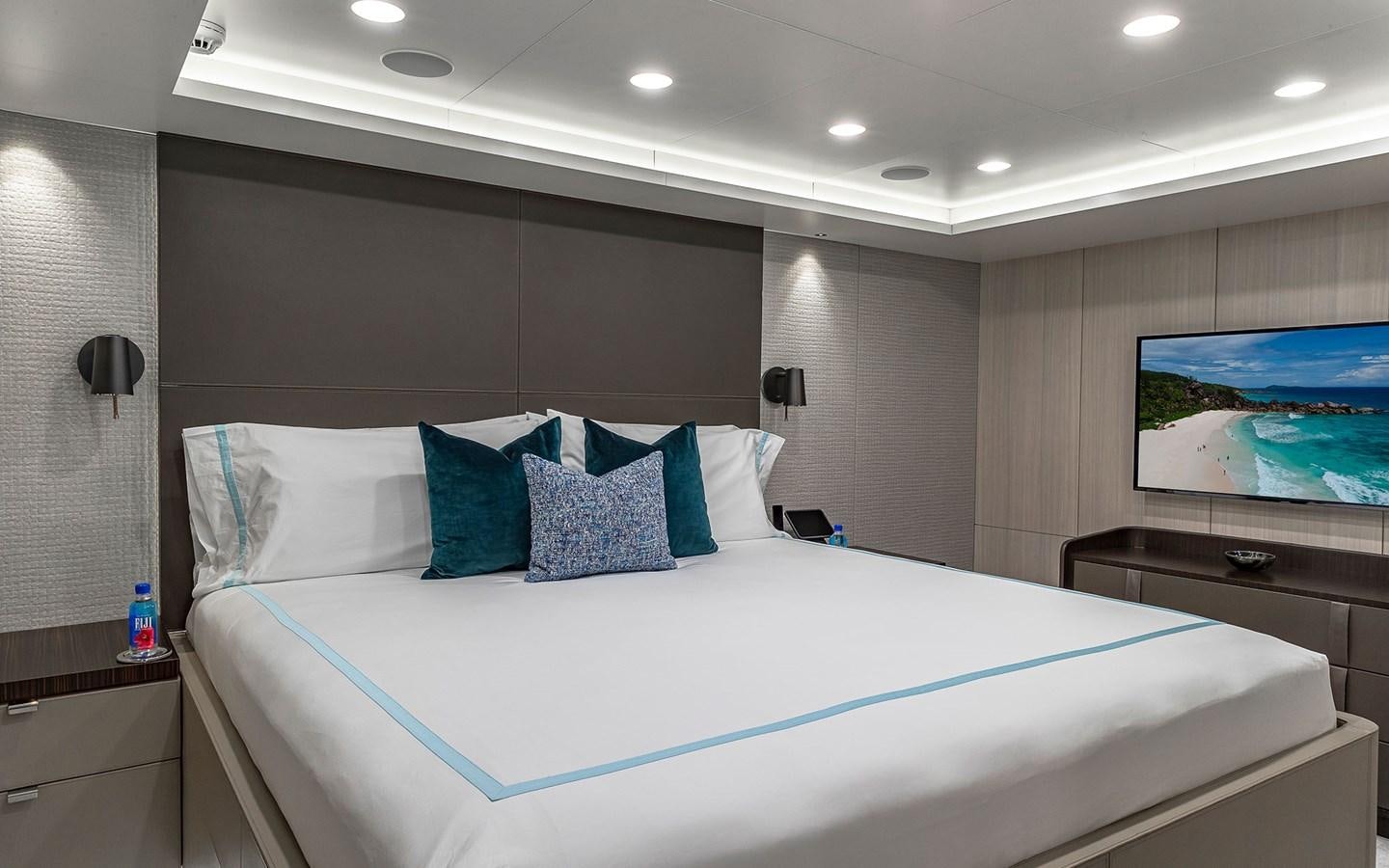 a bed with blue and white pillows aboard REVERIE Yacht for Sale