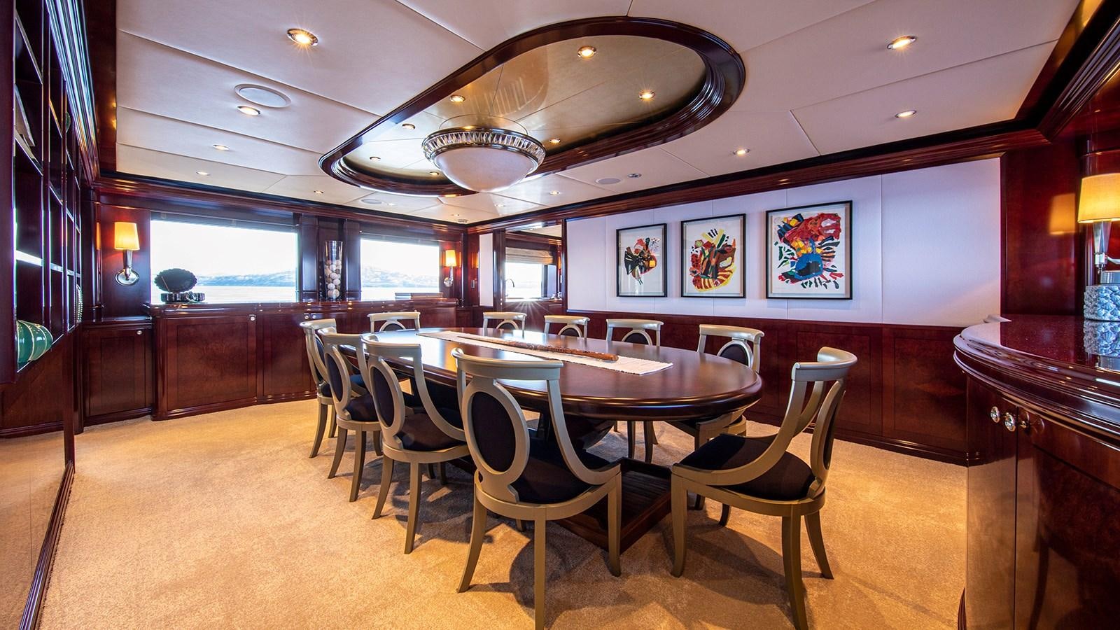 a room with a table and chairs aboard LA DEA II Yacht for Sale
