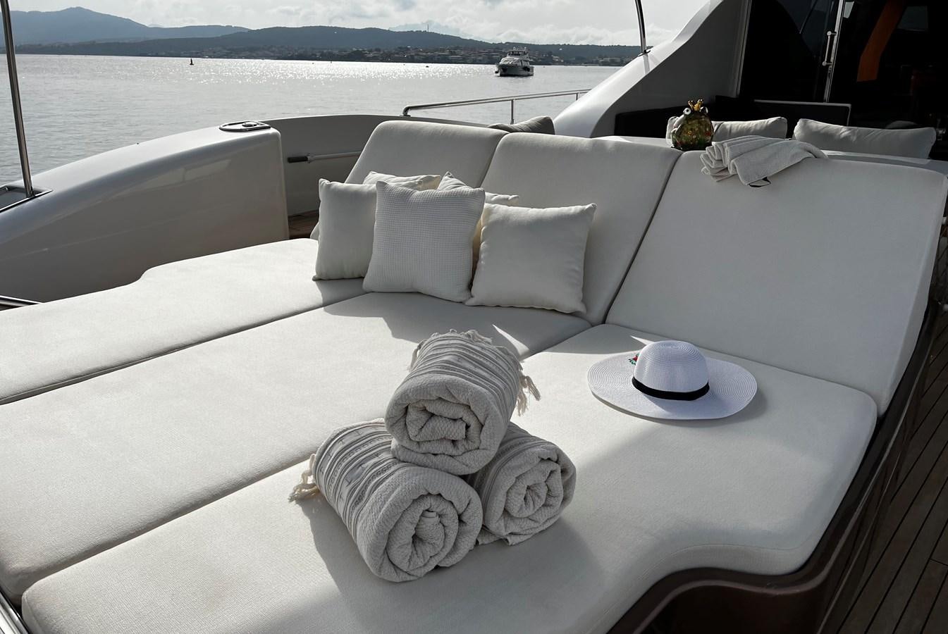 a white couch with pillows and a white coffee table with a white cloth on it aboard SCORPIO Yacht for Sale