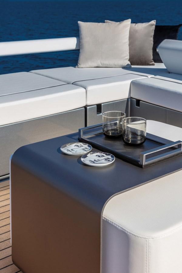 a coffee table with a glass and a tray with a silver tray on it aboard RIVA FOLGORE 88/24 Yacht for Sale