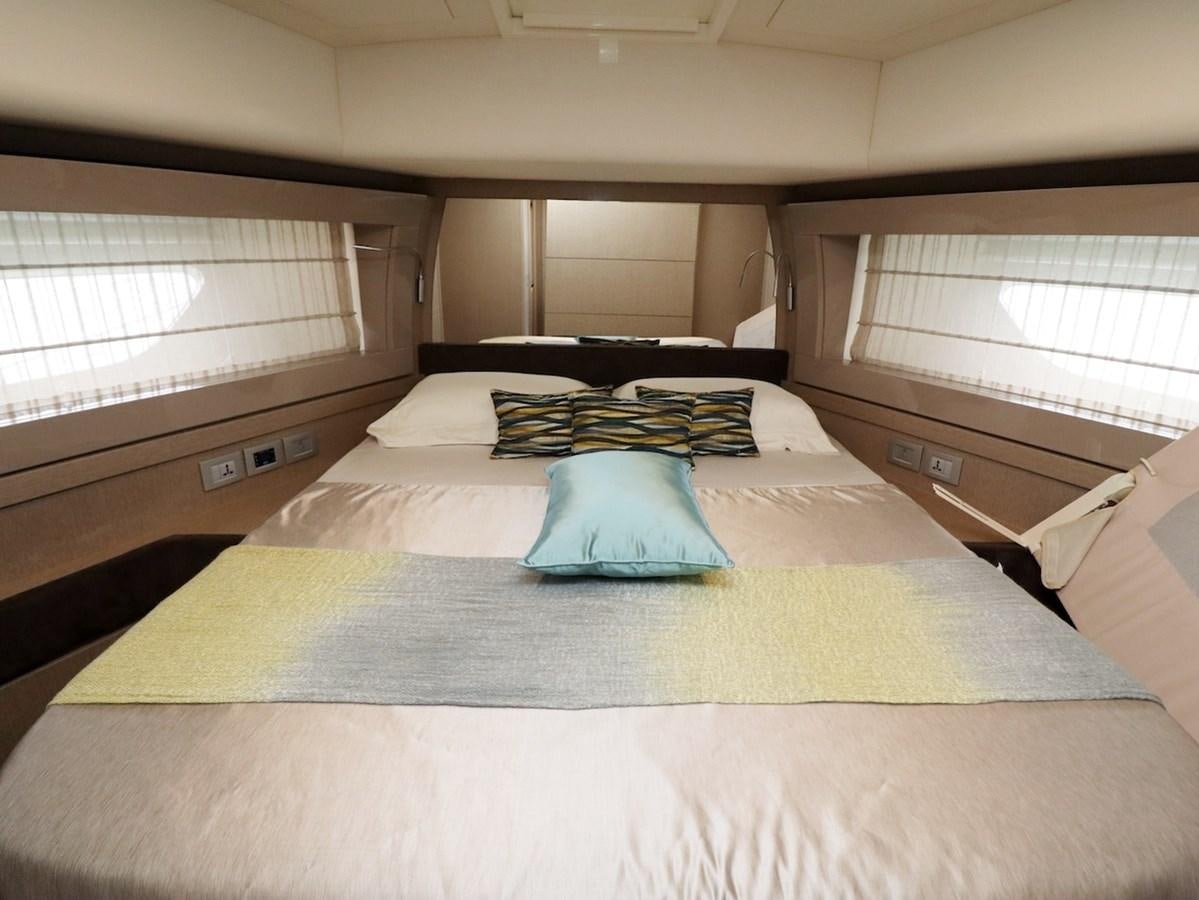 a bed with a white sheet and blue pillow aboard SONIA Yacht for Sale