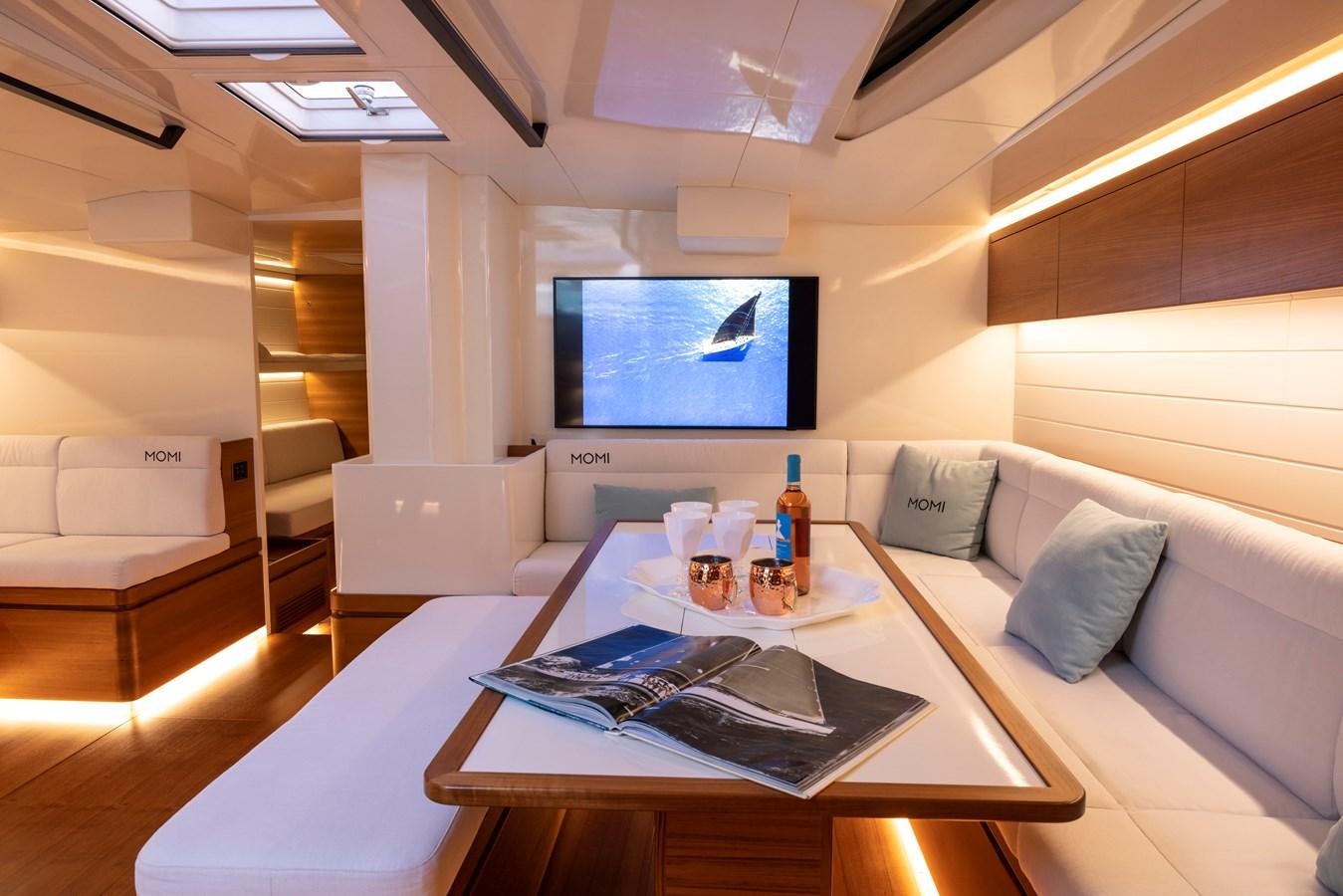 a room with a couch and a tv on the wall aboard MOMI Yacht for Sale