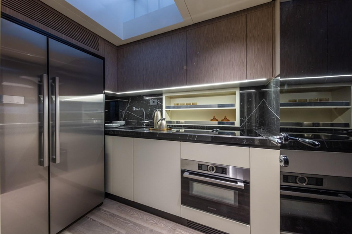 a kitchen with stainless steel appliances aboard ARCADIA SHERPA 80 Yacht for Sale