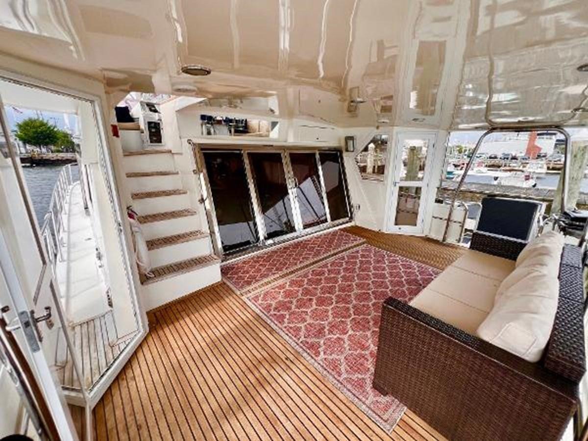 a room with a red rug and white couches aboard SOTITO Yacht for Sale