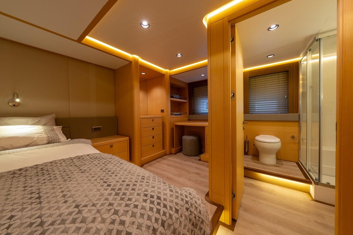 a bedroom with a bed and a mirror aboard JASMINA III Yacht for Sale