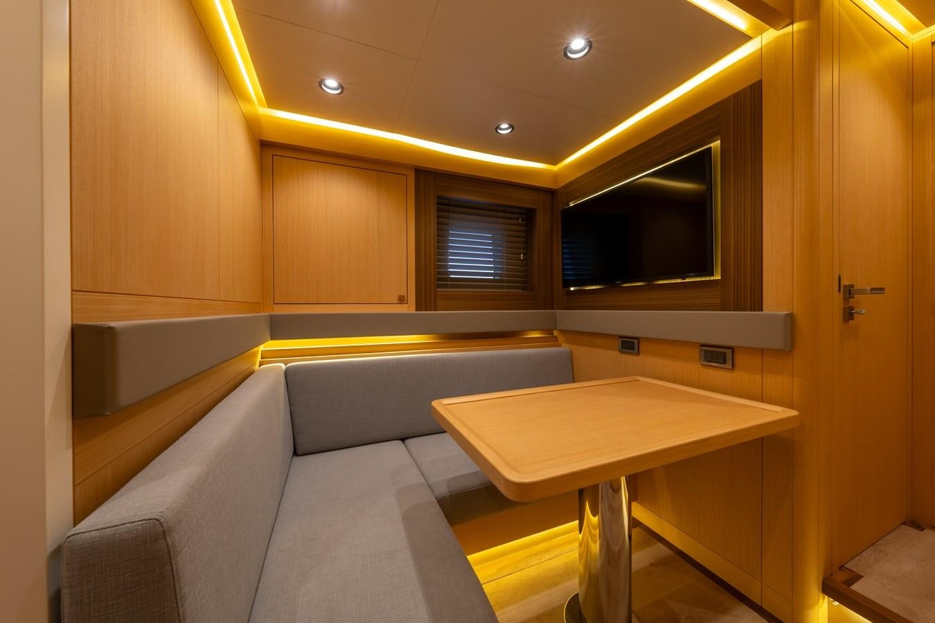 a room with a table and couch aboard JASMINA III Yacht for Sale