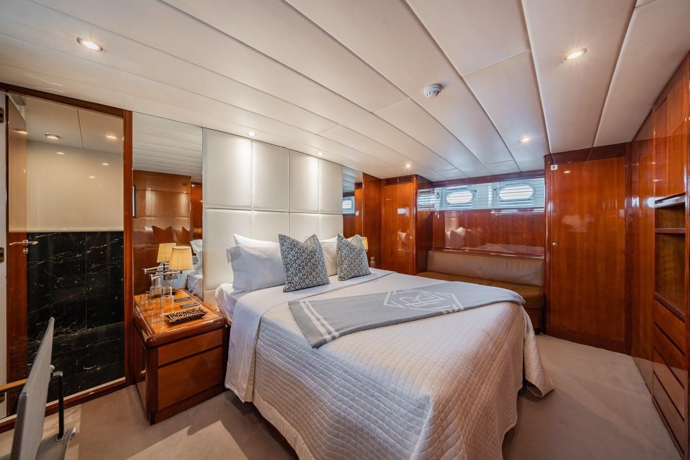 a bedroom with a bed and a fireplace aboard MOONRAKER II Yacht for Sale