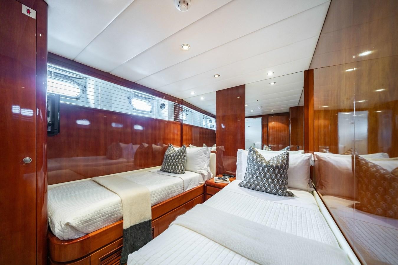 a room with beds and a mirror aboard MOONRAKER II Yacht for Sale