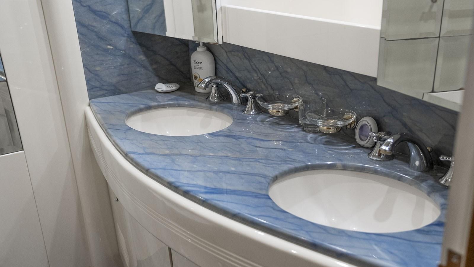 a bathroom sink with two mirrors aboard TITAN Yacht for Sale