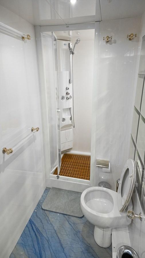 a bathroom with a toilet and a shower aboard TITAN Yacht for Sale