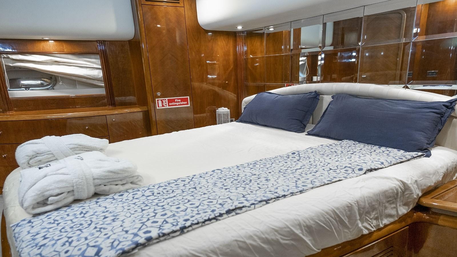 a bed with white sheets aboard TITAN Yacht for Sale