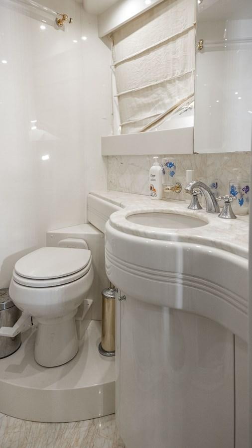 a bathroom with a toilet sink and a mirror aboard TITAN Yacht for Sale