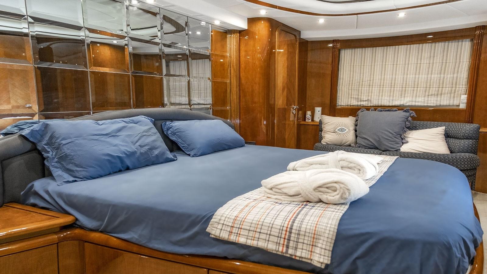 a room with a bed and a wood wall aboard TITAN Yacht for Sale