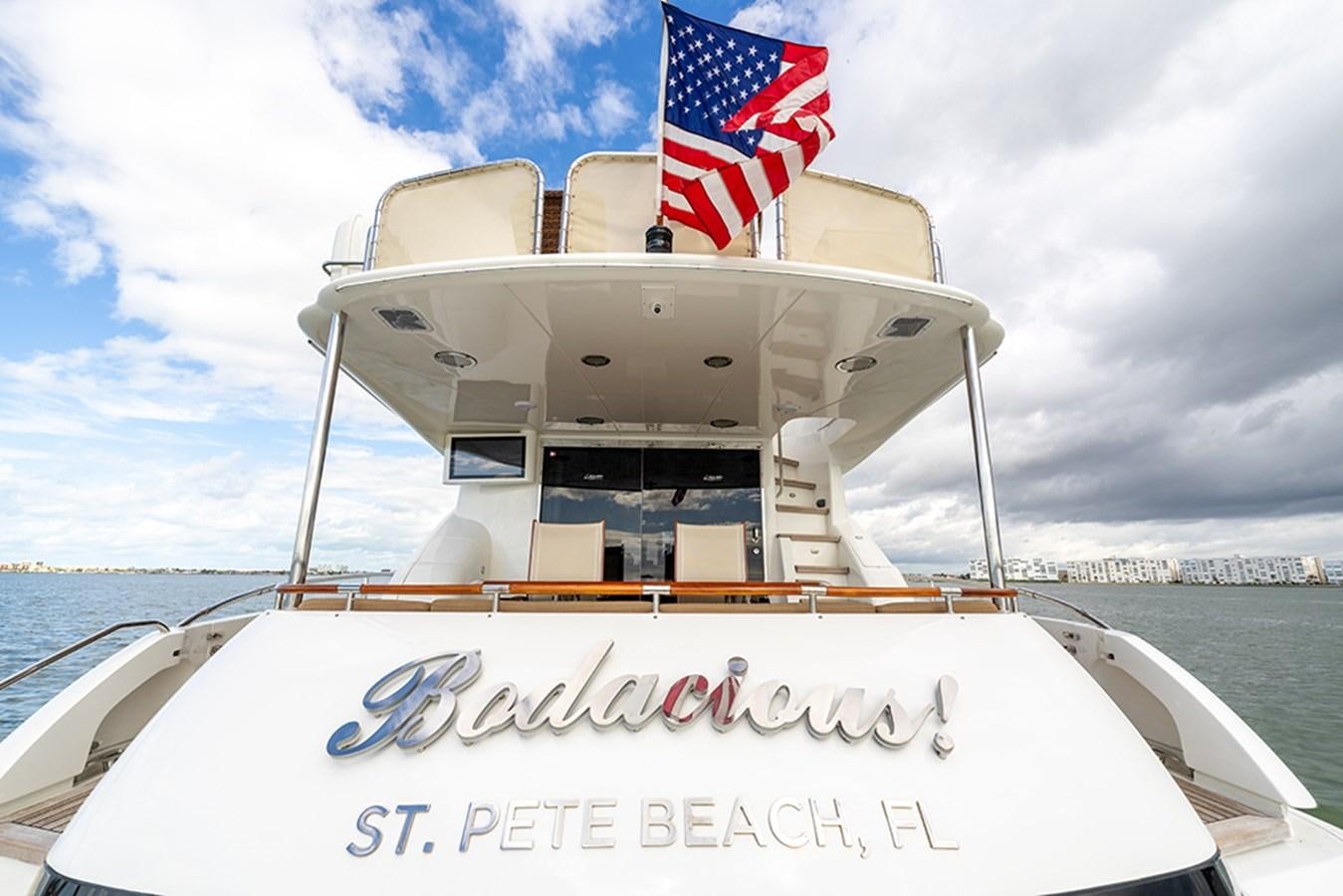 a boat with a flag on the front aboard BODACIOUS VI Yacht for Sale