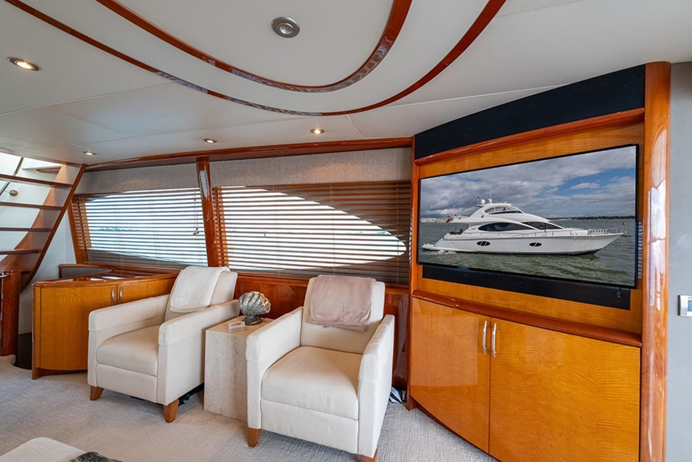 a living room with a tv and furniture aboard BODACIOUS VI Yacht for Sale