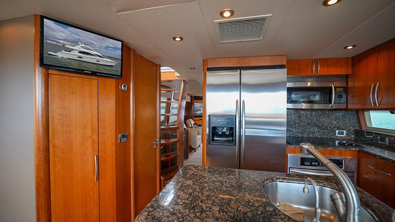 a kitchen with a stainless steel refrigerator aboard BODACIOUS VI Yacht for Sale