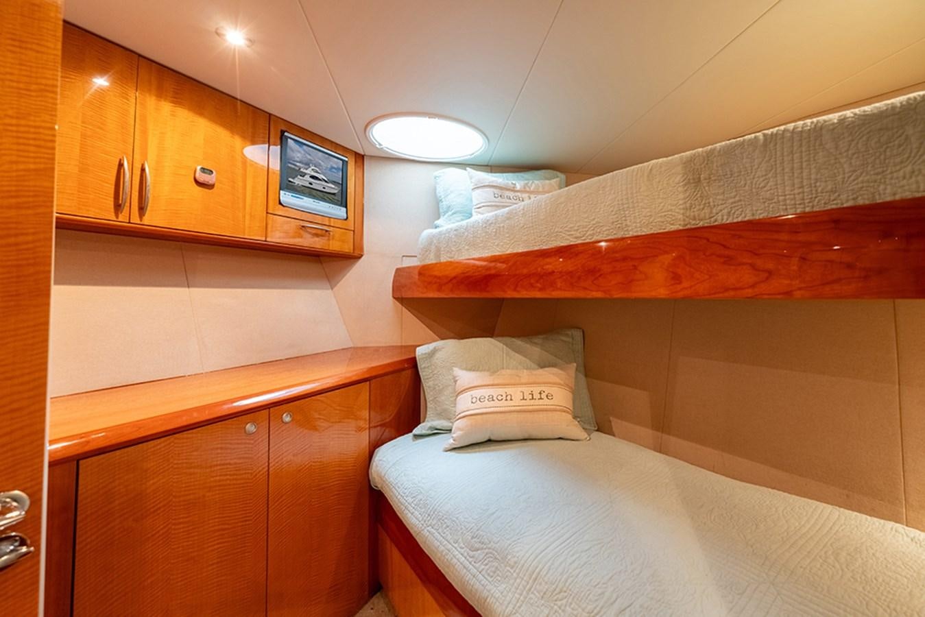 a room with wooden cabinets and a television on the wall aboard BODACIOUS VI Yacht for Sale