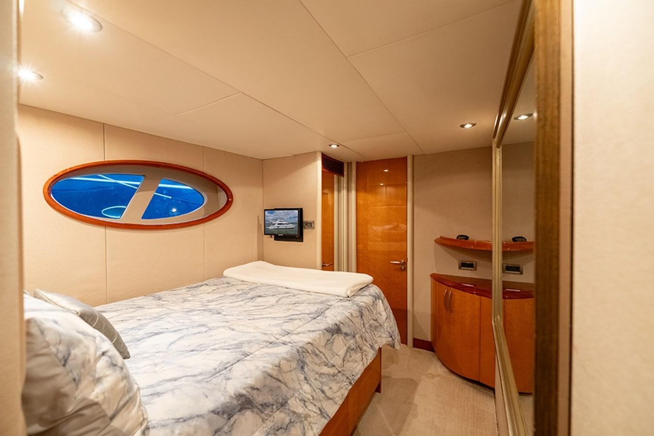 a bedroom with a bed and a desk aboard BODACIOUS VI Yacht for Sale