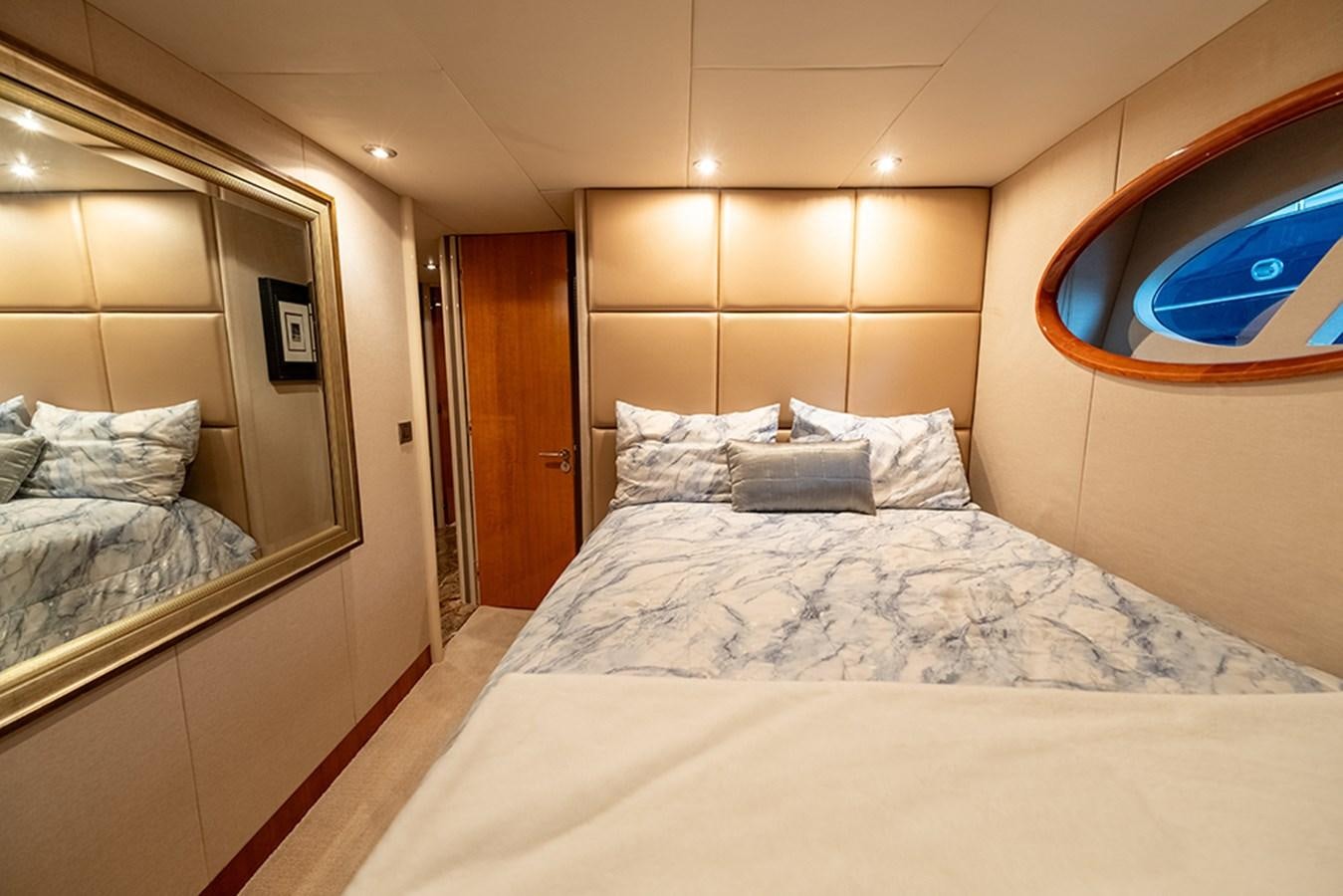 a bed with a white bed spread aboard BODACIOUS VI Yacht for Sale