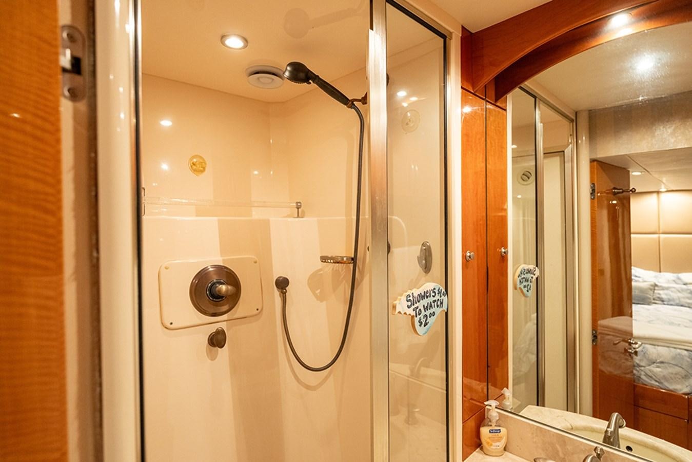 a bathroom with a shower unit and a mirror aboard BODACIOUS VI Yacht for Sale