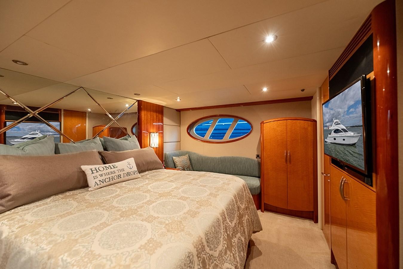 a bedroom with a bed and a television aboard BODACIOUS VI Yacht for Sale