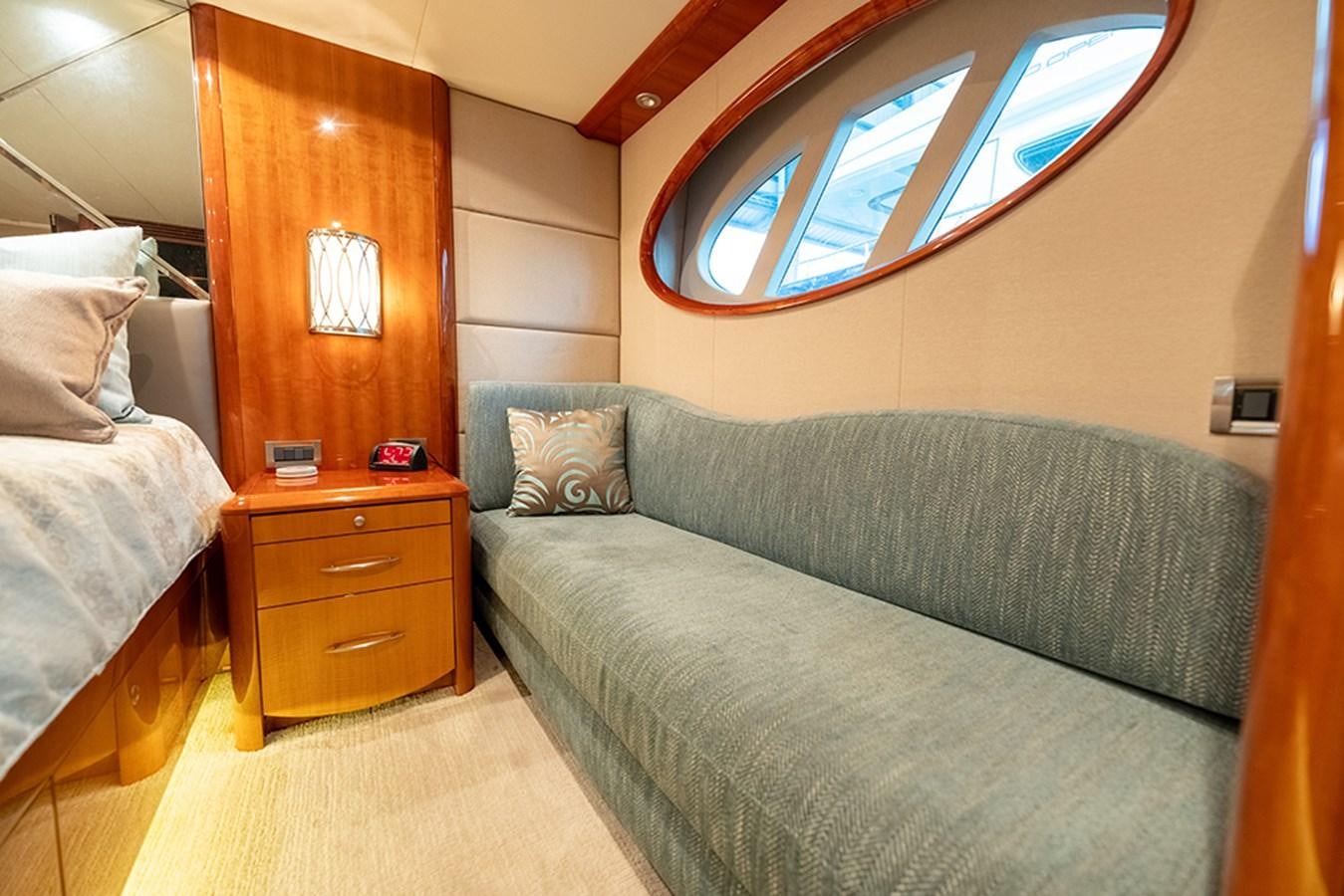 a bedroom with a bed and a window aboard BODACIOUS VI Yacht for Sale
