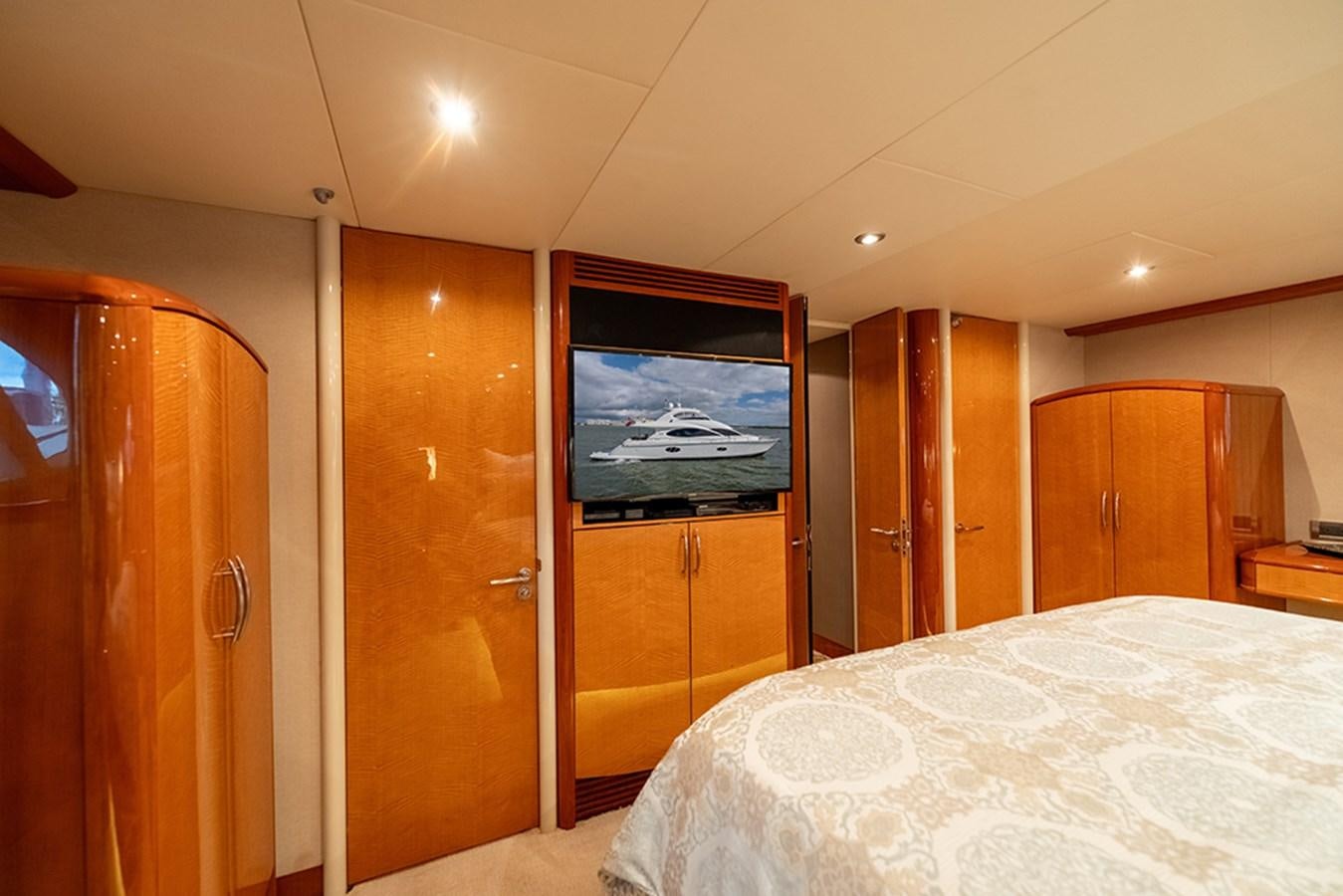 a bedroom with a television on the wall aboard BODACIOUS VI Yacht for Sale