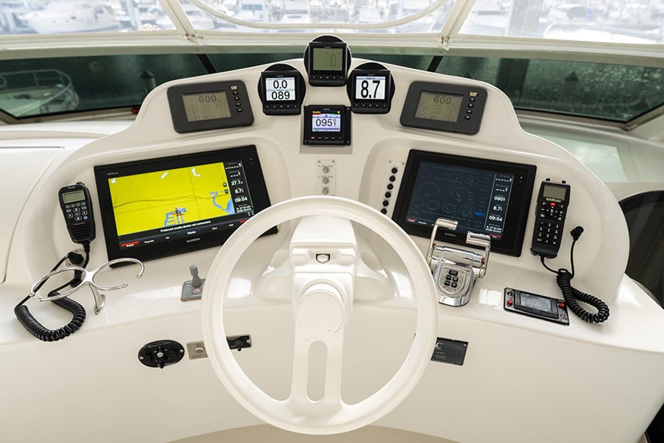 a car interior with a steering wheel and a screen aboard BODACIOUS VI Yacht for Sale