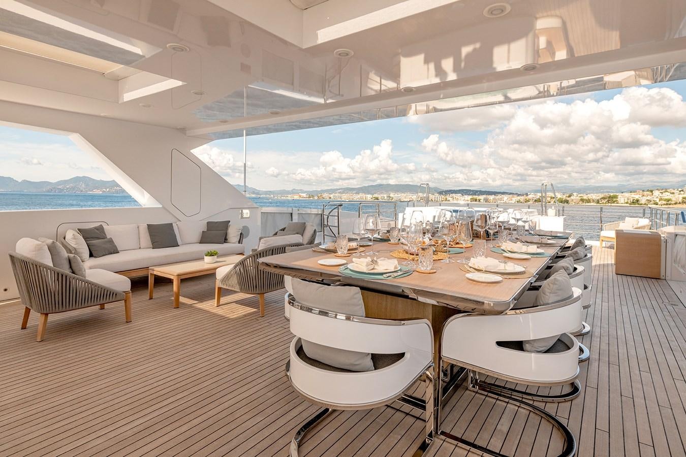 a room with a table chairs and a view of the city aboard MEDIALLY Yacht for Sale