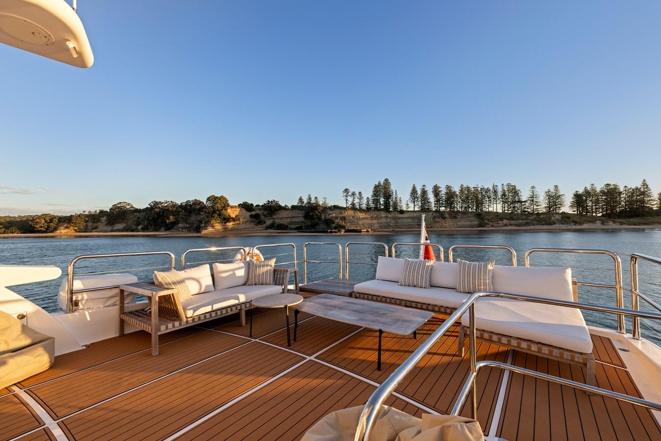 a deck with chairs and a body of water in the background aboard WW Yacht for Sale