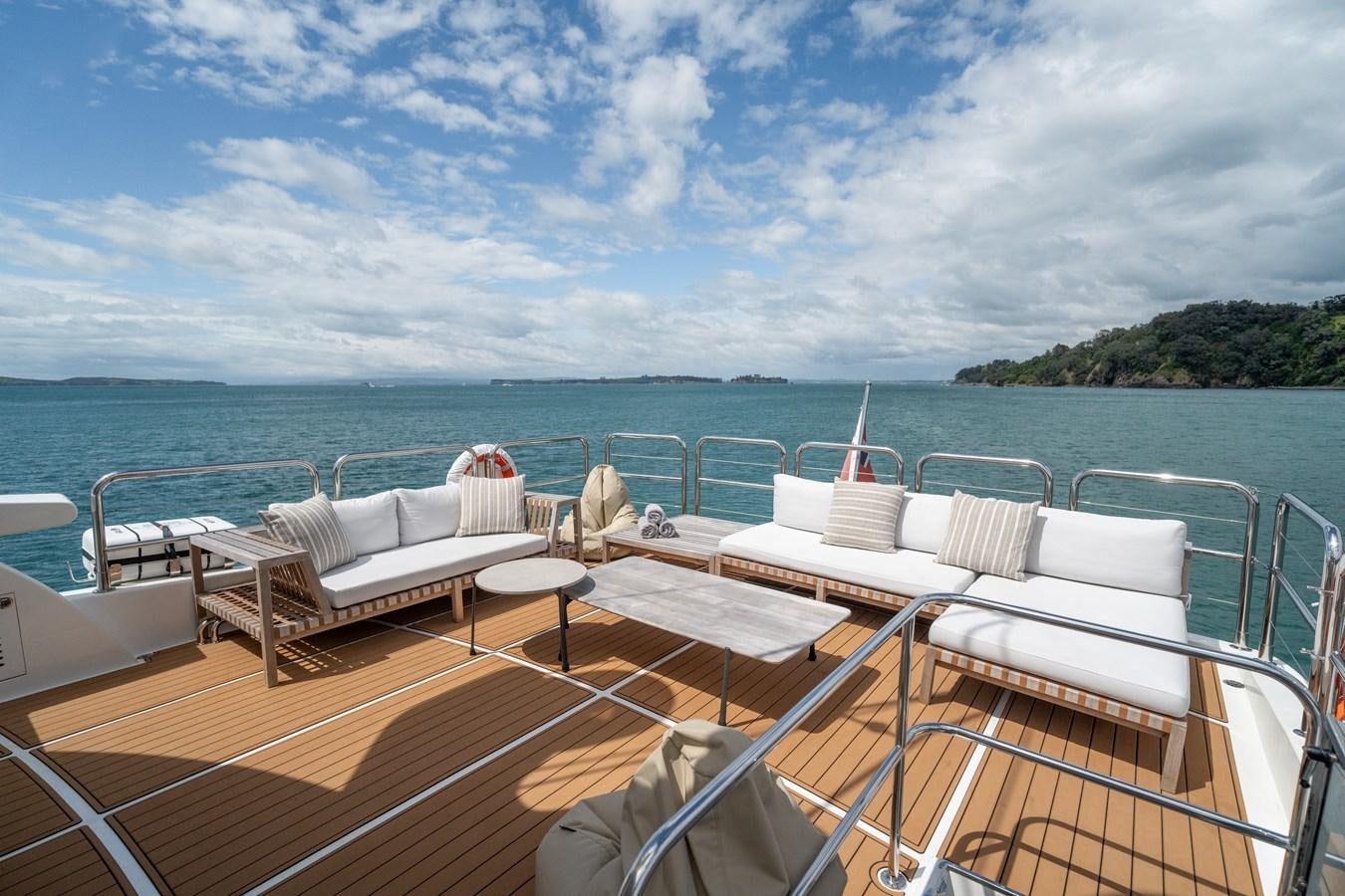 a deck with chairs and tables on it by the water aboard WW Yacht for Sale