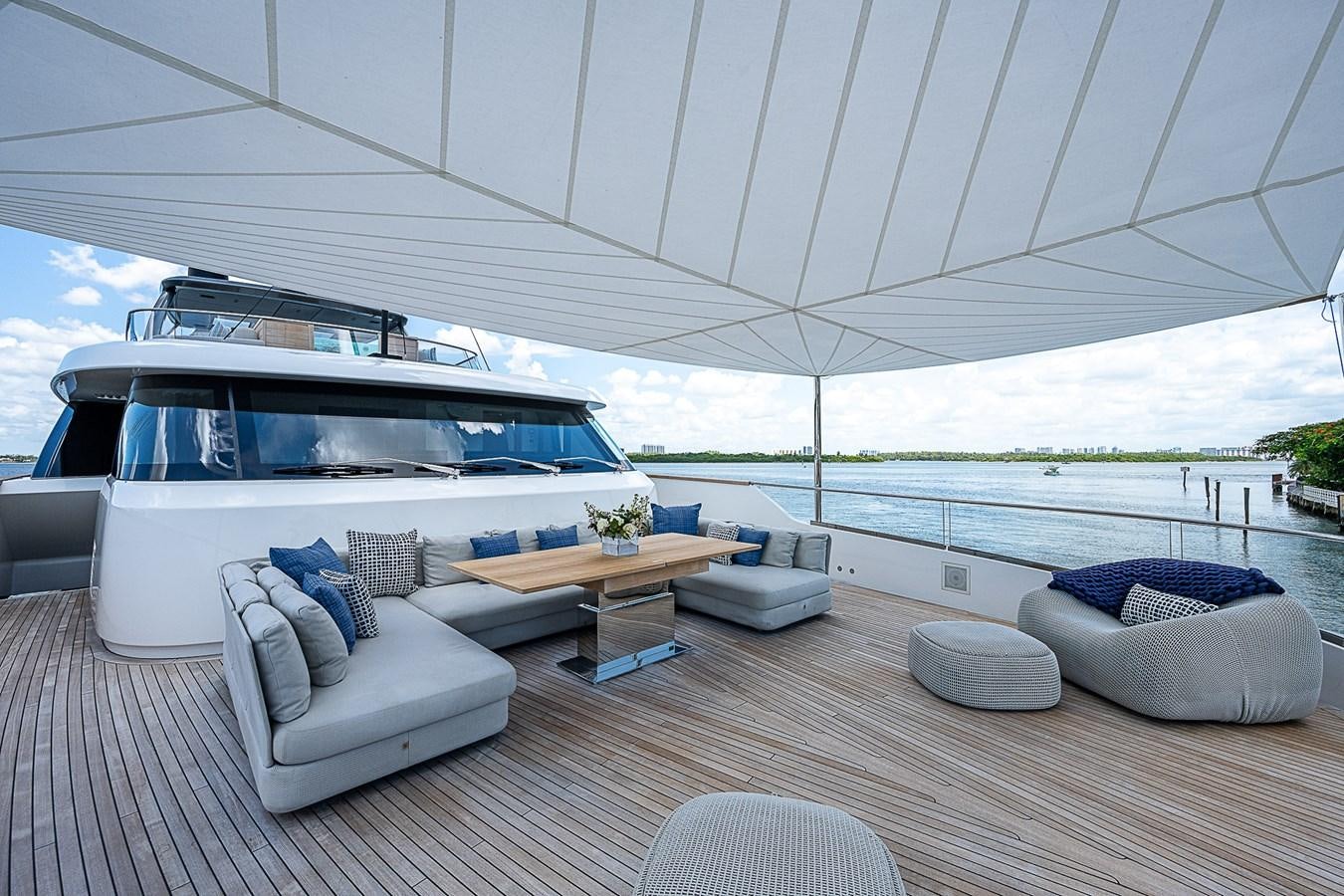 a large white lounge chair next to a large white boat on a deck aboard F 118 Yacht for Sale