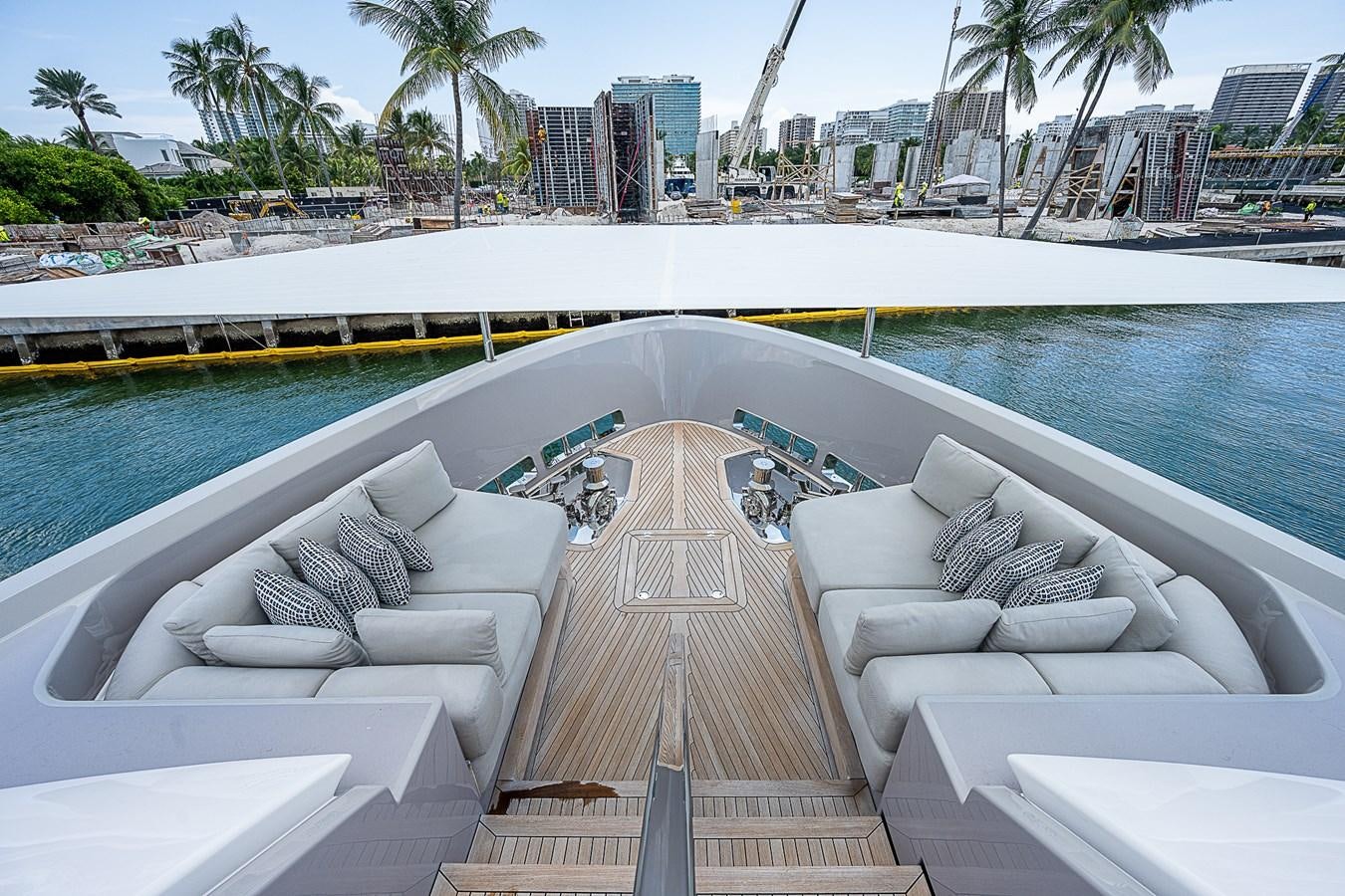 a pool with lounge chairs and a large building in the background aboard F 118 Yacht for Sale
