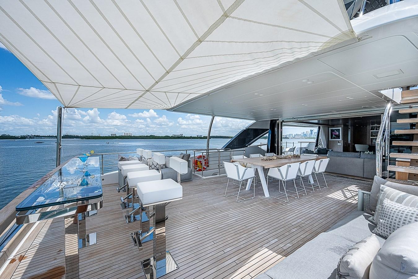 a deck with a large body of water and a deck with chairs and tables aboard F 118 Yacht for Sale