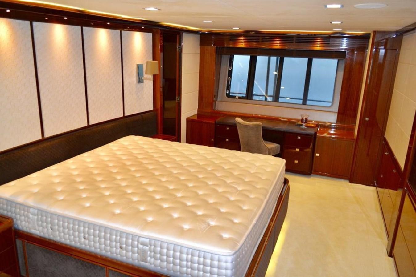 a room with a bed and desk aboard ASPIRATION Yacht for Sale