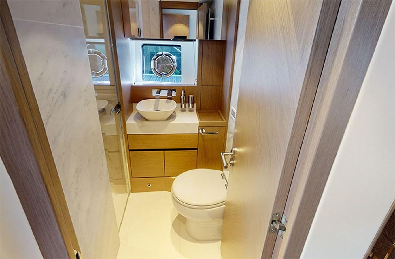a bathroom with a sink toilet and a mirror aboard SM Yacht for Sale