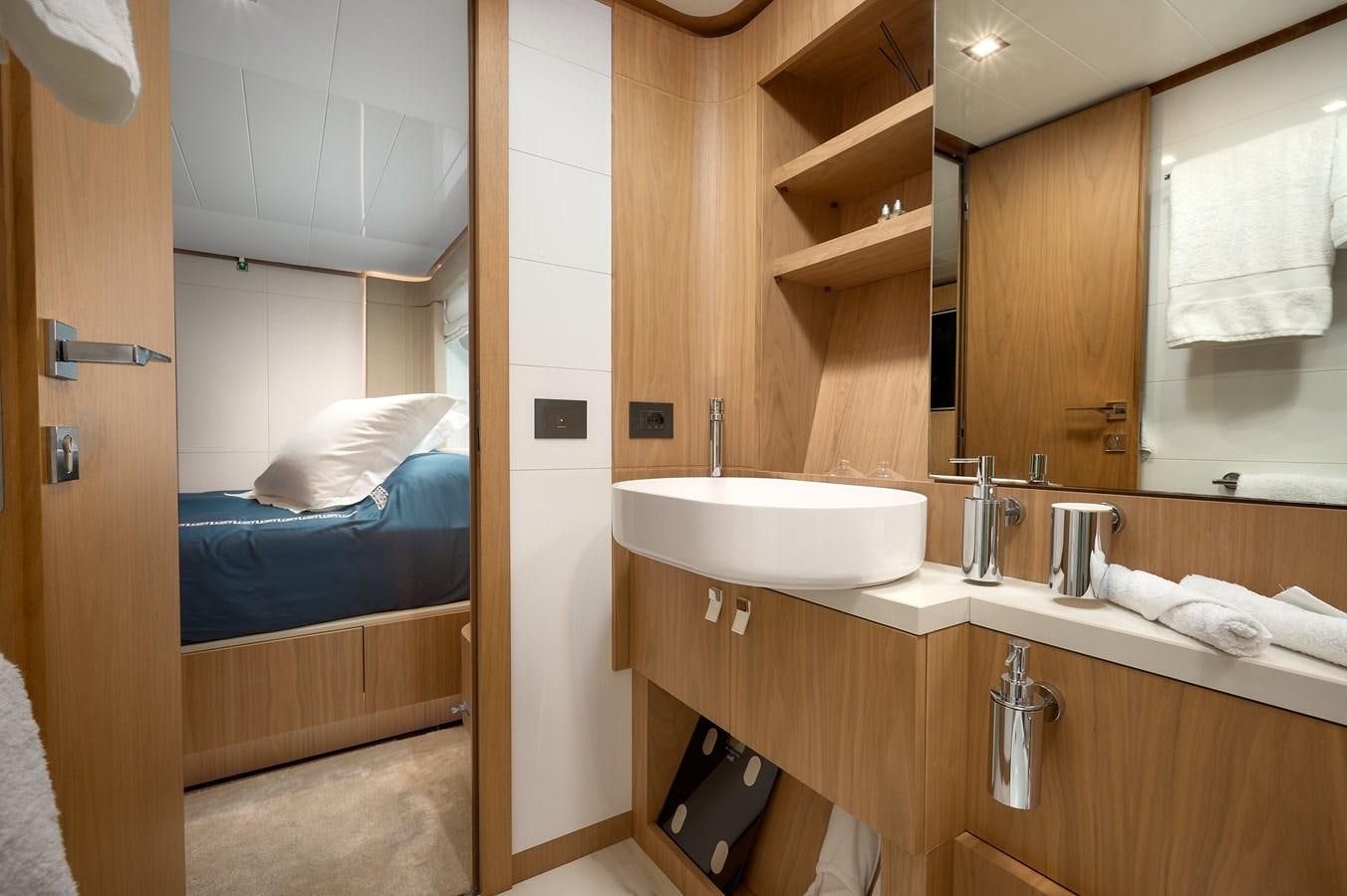 a bathroom with a bed sink and a mirror aboard DAMARI Yacht for Sale