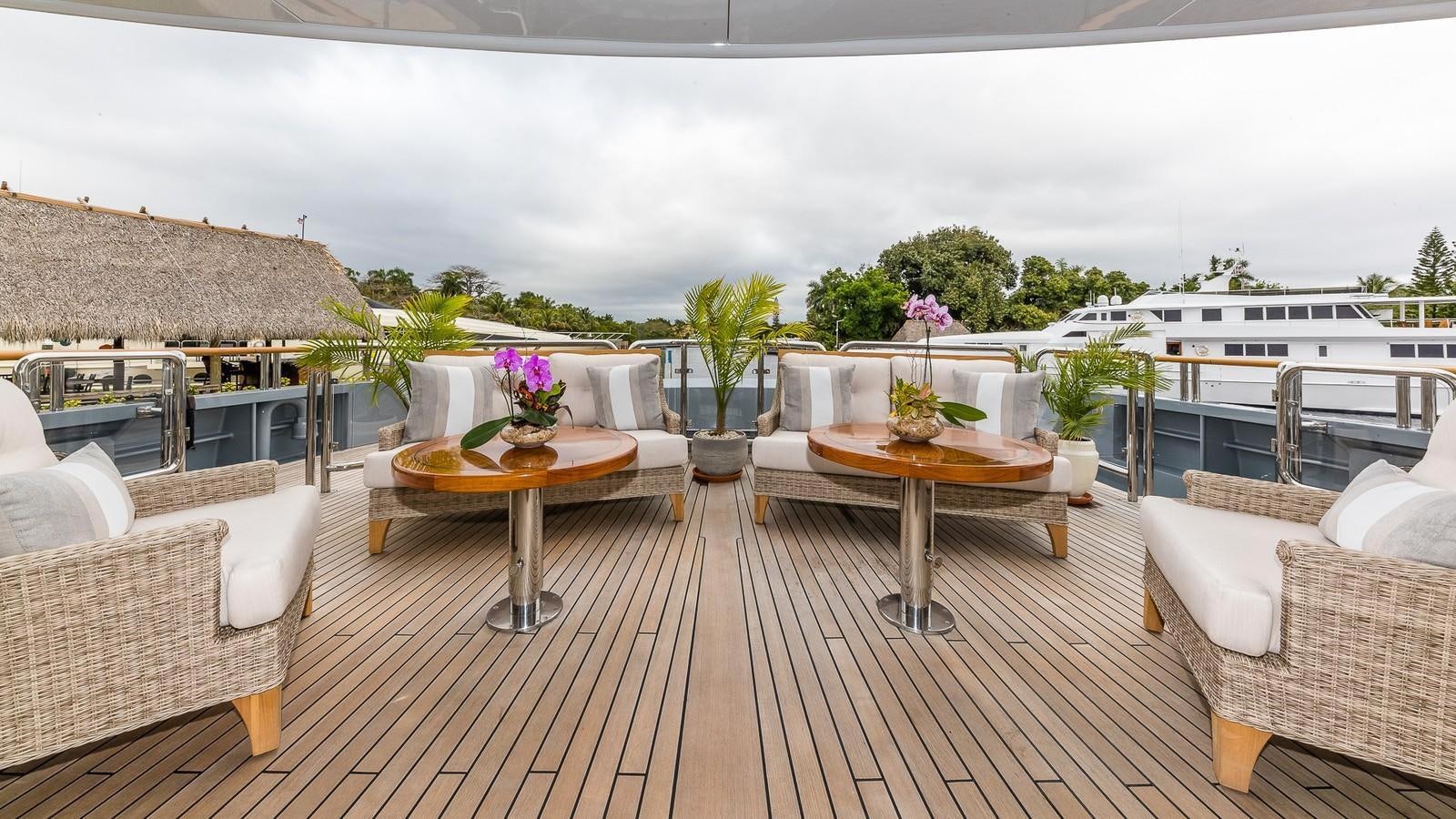 a deck with tables and chairs aboard BELLA Yacht for Sale